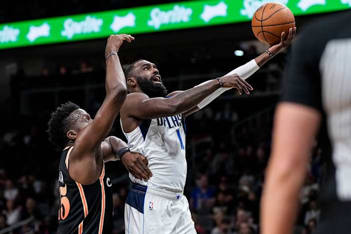 Mavericks guard Tim Hardaway Jr. drives past Hawks center Clint Capela for a left-handed layup.